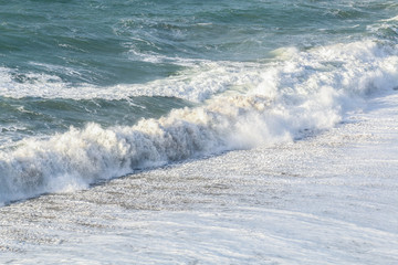 Waves in a rough sea breaking on a Sandy UK beach