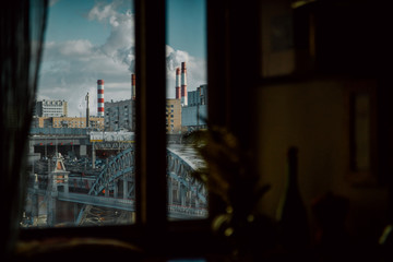 Fototapeta na wymiar View from the window on the iron bridge crossing the river and a monument to Yurii Gagarin the first spaceman against a power plant. Moscow cityscape at spring. 