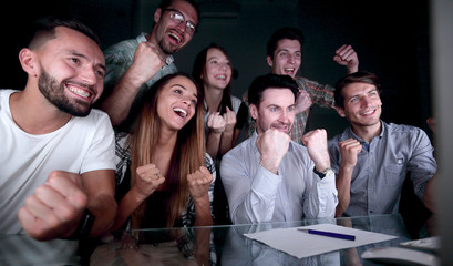 happy business team looking at computer monitor