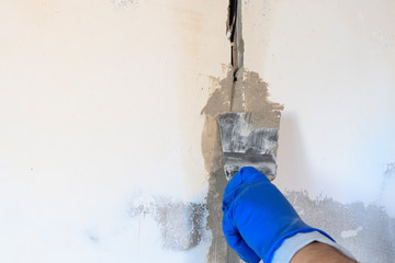 technical hole in it is an electrical wire. the wall is white. Master with a spatula and mortar...