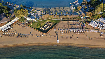 Aerial drone photo of iconic turquoise sandy celebrity beach of Asteras or Astir and ancient temple...
