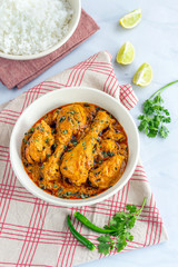 Indian Chicken Curry with Fenugreek. Methi Chicken Served in a Bowl on White Background Vertical Photo.