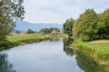 Fototapeta na wymiar idyllic landscape view of riverbanks of gacka in central croatia