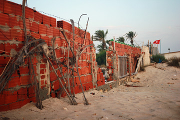 Fototapeta na wymiar Destroyed wall on Tunisian beach