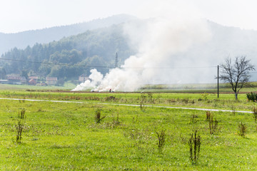 smoke clouds over green field in rural central croatia