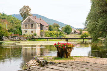 idyllic old wooden mill and bridge at gacka river in central croatia © Janine