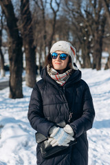 Fototapeta na wymiar Winter portrait of young attractive smiling woman in mirror sunglasses