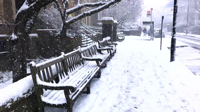 Snowy London city scene with snowy benches at a Bus Stop