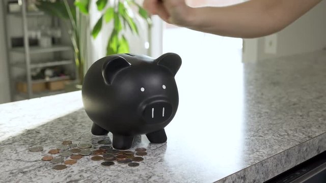 Woman putting coins in piggy bank