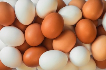 many beautiful delicious bright chicken eggs of orange and white color lying on top of each other