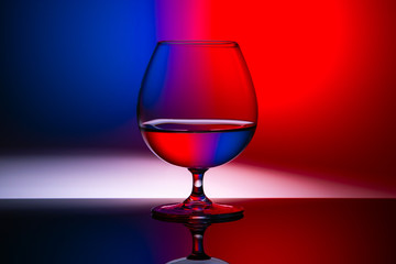 horizontal image of a glass on a red-blue background