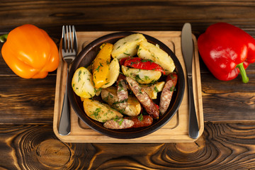 Sausages and potato with a paprika on a ceramic plate