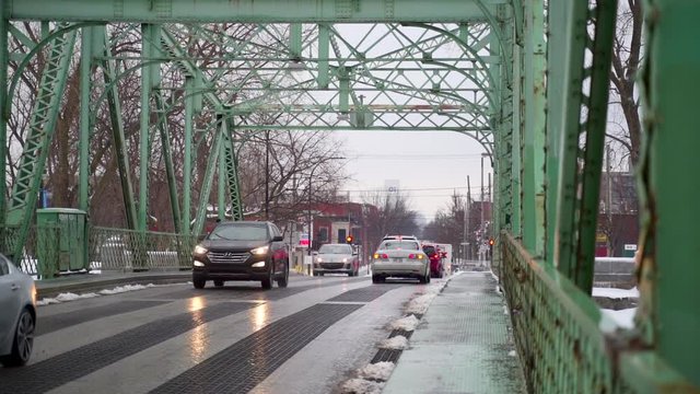 Cinematic b-roll footage of a bridge with cars passing by during winter season.