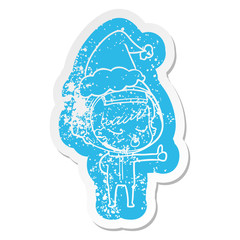 cartoon distressed sticker of a pretty astronaut girl giving thumbs up wearing santa hat