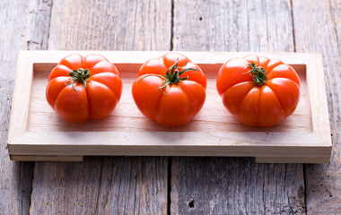 Natural fresh tomatoes on the wood.