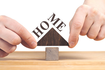 Real estate concept. Wooden house model on wooden table, white background