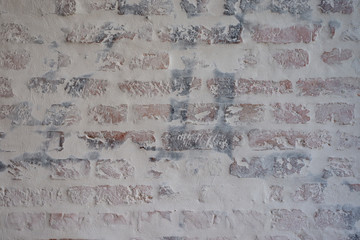 Verputztes Mauerwerk aus Ziegelsteinen mit grauen Fugen