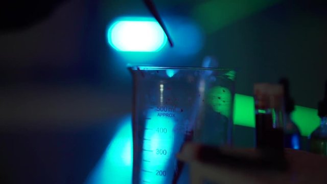 Dripping Liquid into Beaker with Dropper in Creepy Lab