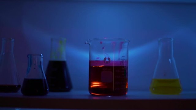 Tracking Shot of Beakers in a Dark Lab