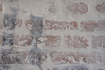 Verputztes Mauerwerk aus Ziegelsteinen mit grauen Fugen