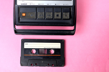 Old retro vintage 80s style portable cassette recorder radio and audio  tape cassette on a pink background