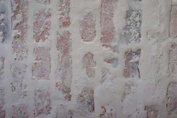 Verputztes Mauerwerk aus Ziegelsteinen mit grauen Fugen