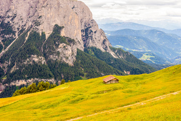 Obraz premium Italy, Alpe di Siusi, Seiser Alm with Sassolungo Langkofel Dolomite, an old barn in a field