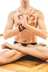 A man who do yoga on the wooden floor