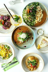 Gourmet meat meals assortment flat lay. Top view on restaurant table with menu of tasty grilled snacks. Concept for restaurant menu.