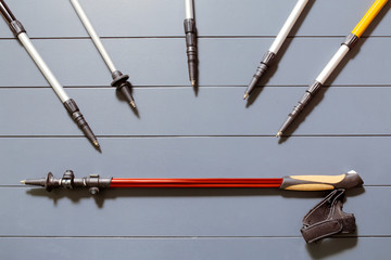 Flat lay top view of set of many hiking or ski poles on a wooden background