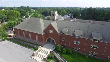 Aerial view of an old school building with a stone tower behind in Pennsylvania.