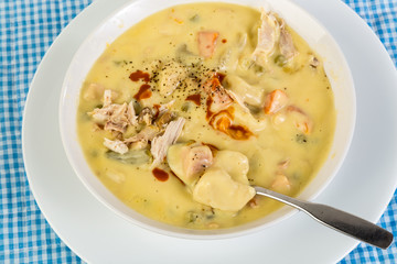 Overhead View of Chicken and Dumpling Stew with Dollop of Hot Sauce