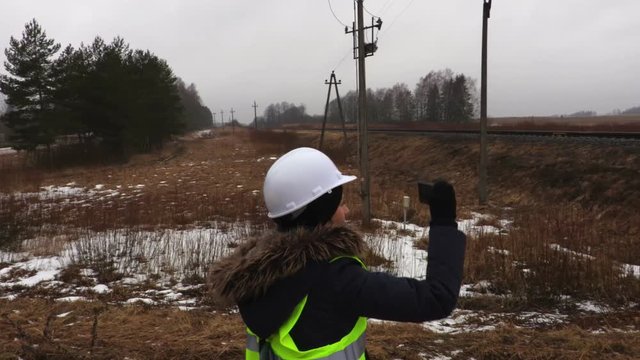 Female railway engineer take pictures of power transformer