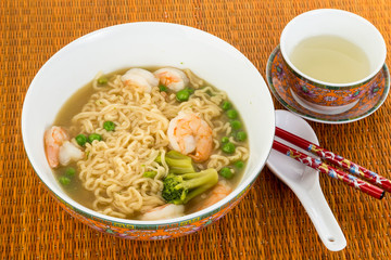 Shrimp and Noodle Soup with Tea and Chopsticks on Bamboo Place Mat