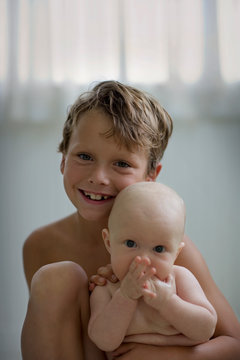 Portrait of a young boy holding his baby brother.