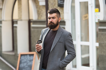 Make this day with coffee. Bearded man enjoying morning coffee. Drinking his cup first thing in morning. Businessman in hipster style holding takeaway coffee. Hipster with paper cup walking in city