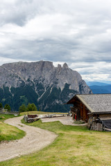 Fototapeta na wymiar Italy, Alpe di Siusi, Seiser Alm with Sassolungo Langkofel Dolomite, an old barn in a field