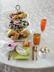 afternoon tea service with dessert and finger food tray setting on white linen table cloth