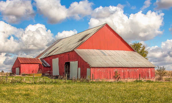 A beautiful red barn and clouds and a gorgeous autumn day. 