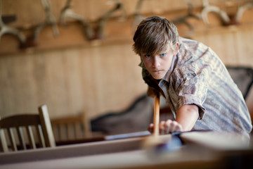 Focused teenage boy playing pool.
