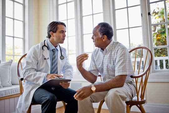 Concerned senior man talking over healthcare options with his family doctor.