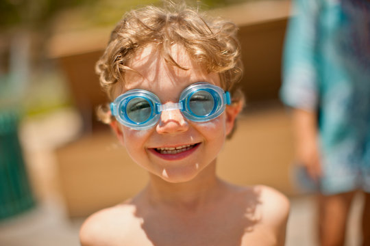 Portrait of a smiling young boy wearing swimming goggles.