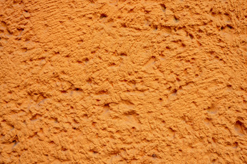 Orange Hauswand mit Rauhputzverkleidung