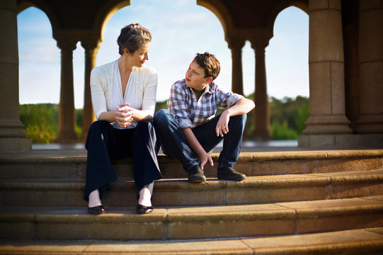 Mother and son sitting on the steps of an opulent rotunda. 