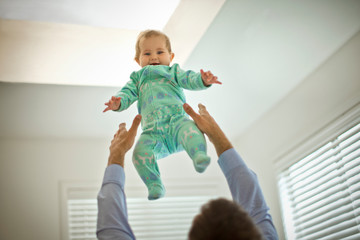 Father throwing and catching his baby girl.