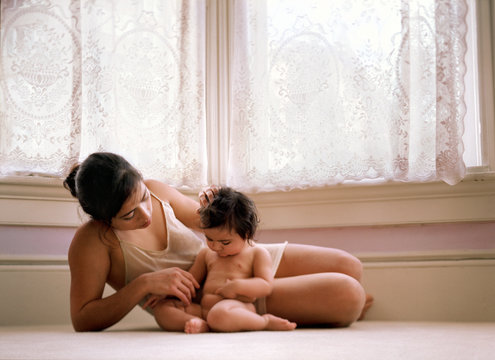 A mother is playing with her baby.