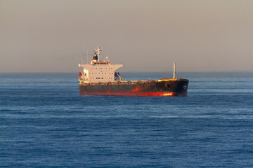 Fototapeta premium Old rusty bulk cargo ship at anchorage
