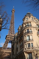 Fototapeta na wymiar Paris, immeuble d'angle haussmannien et vue sur la tour Eiffel (France)