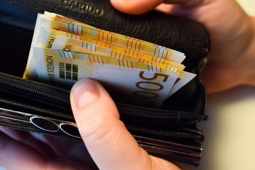 Banknotes of 500 NOK are in the wallet. Open wallet with money.