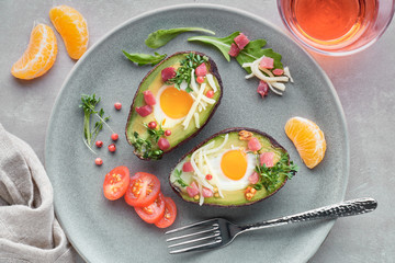Keto diet dish: Avocado boats with ham cubes, quail eggs and cheese, top lay